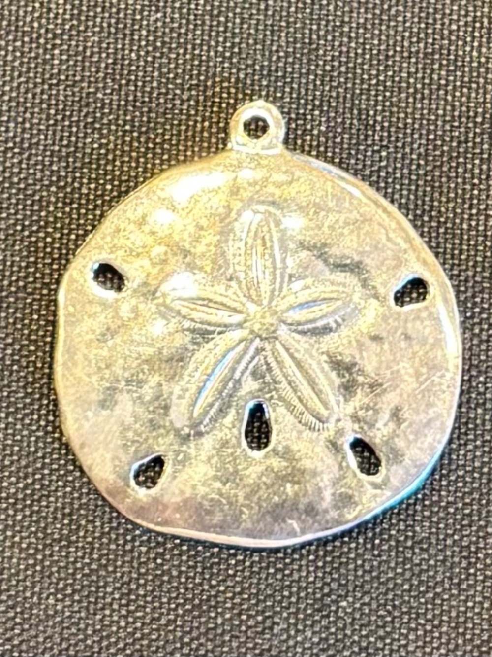 1" Sterling Silver Sand Dollar Charm.  You would need to add a jump ring to hook